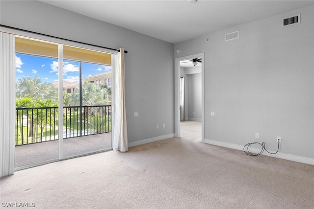 spare room with ceiling fan and light carpet