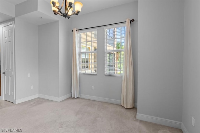 carpeted empty room featuring a chandelier