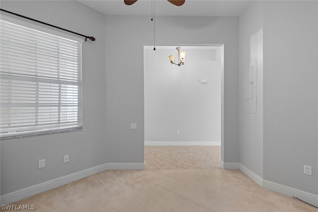 empty room featuring ceiling fan and light colored carpet