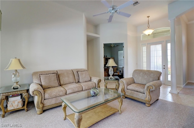 tiled living room with ceiling fan and ornate columns