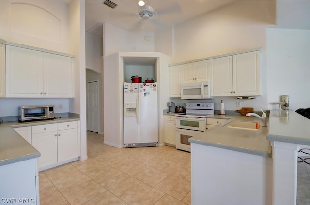 kitchen featuring ceiling fan, white cabinets, white appliances, light tile patterned floors, and a towering ceiling