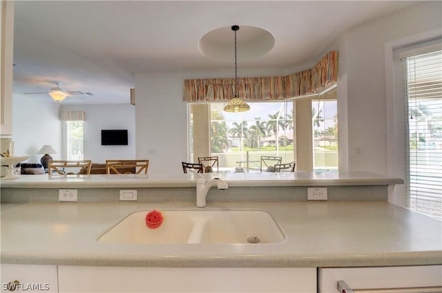 kitchen with hanging light fixtures, sink, and a wealth of natural light