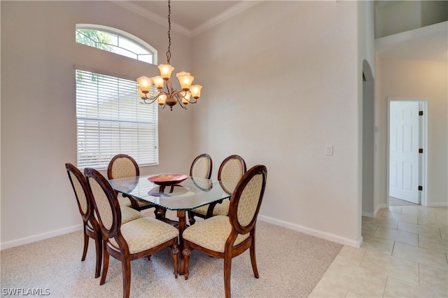 dining space with a chandelier, ornamental molding, light tile patterned floors, and a high ceiling