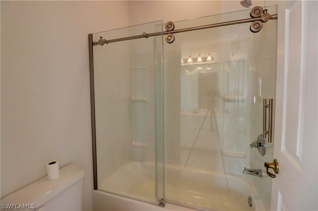 bathroom with enclosed tub / shower combo and toilet