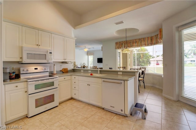 kitchen with plenty of natural light, kitchen peninsula, and white appliances