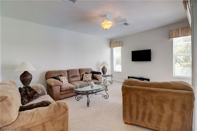 carpeted living room with ceiling fan and plenty of natural light