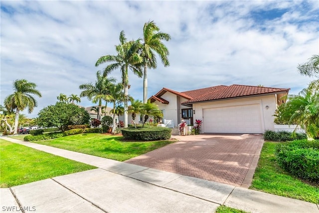 mediterranean / spanish-style house featuring a garage and a front lawn