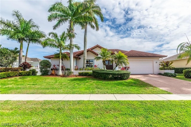 mediterranean / spanish-style house with a garage and a front lawn