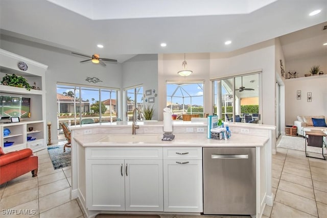 kitchen featuring dishwasher, sink, light tile patterned floors, and white cabinets