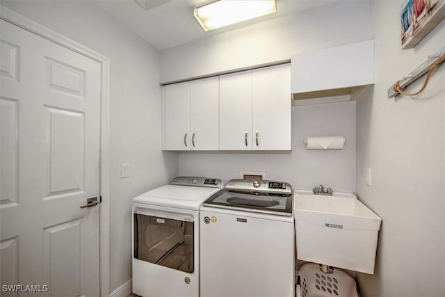 washroom with cabinets, sink, and washing machine and dryer