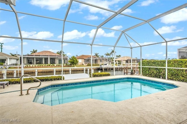 view of swimming pool with glass enclosure and a water view