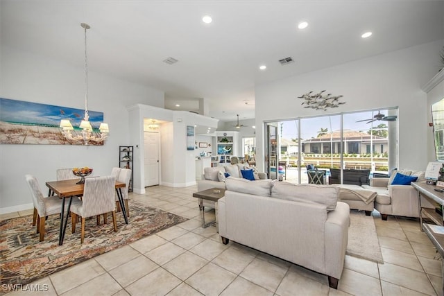 tiled living room featuring ceiling fan with notable chandelier and a towering ceiling