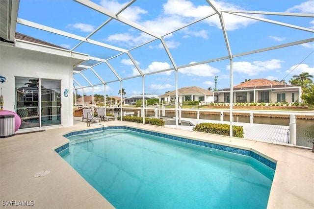 view of swimming pool with a water view, glass enclosure, and a patio area