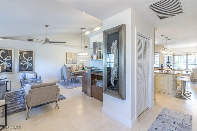 living room with ceiling fan and vaulted ceiling