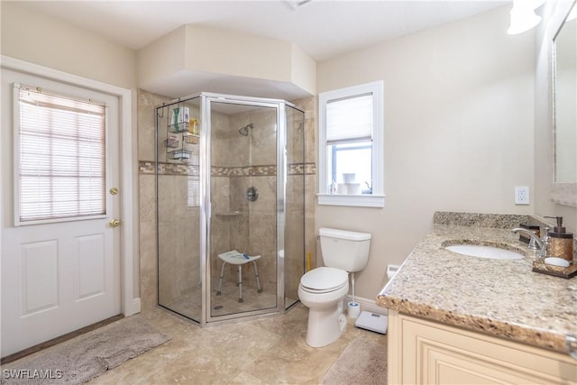 bathroom featuring vanity, plenty of natural light, a shower with door, and toilet