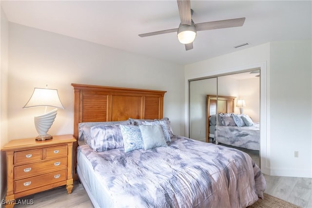 bedroom with ceiling fan, light hardwood / wood-style floors, and a closet