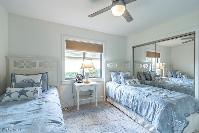 bedroom featuring hardwood / wood-style flooring, ceiling fan, and a closet