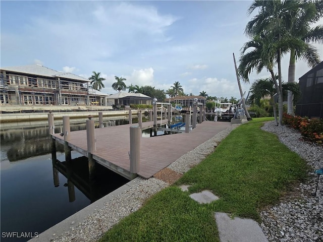 dock area with a lawn and a water view