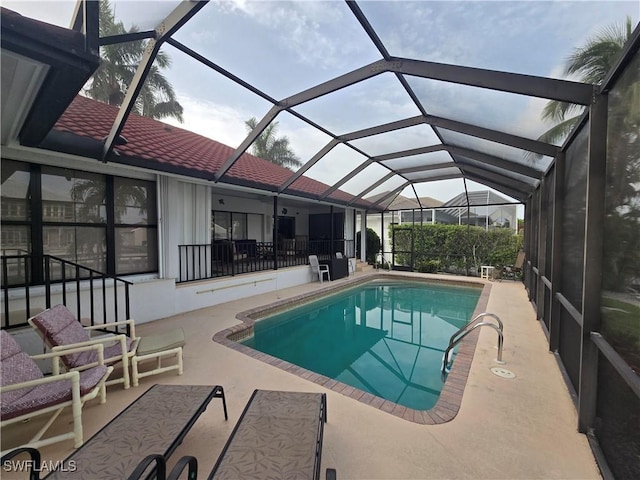 view of swimming pool featuring a lanai and a patio