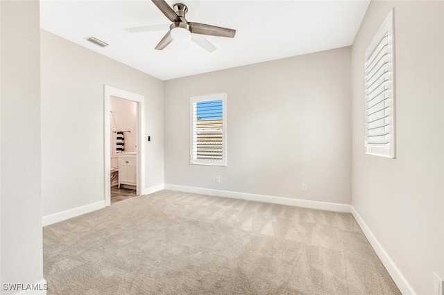 unfurnished room featuring light carpet, baseboards, visible vents, and ceiling fan