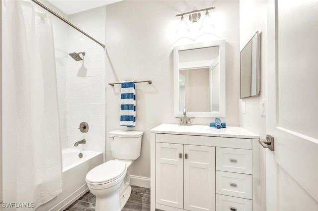 bathroom with vanity, shower / bath combination with curtain, toilet, and baseboards