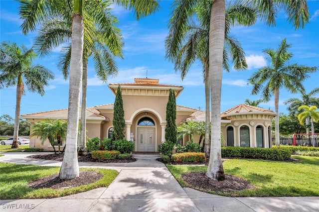 mediterranean / spanish-style house with a front lawn and stucco siding