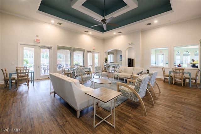 living area featuring visible vents, a tray ceiling, wood finished floors, and french doors