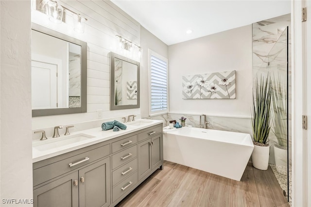 bathroom with hardwood / wood-style flooring, vanity, and separate shower and tub