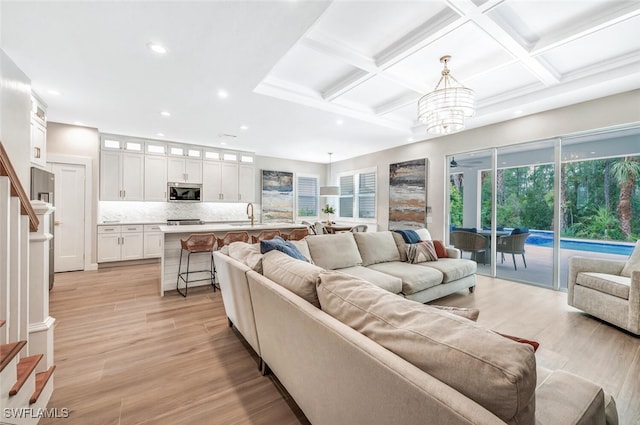 living room featuring light hardwood / wood-style floors, sink, and plenty of natural light