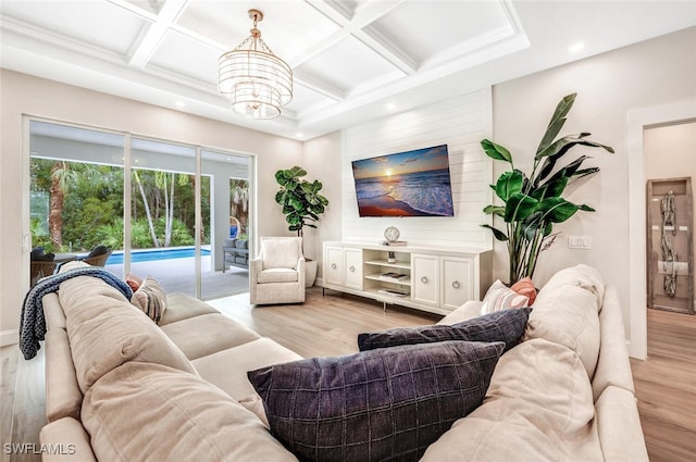 living area featuring light wood finished floors, coffered ceiling, and beamed ceiling