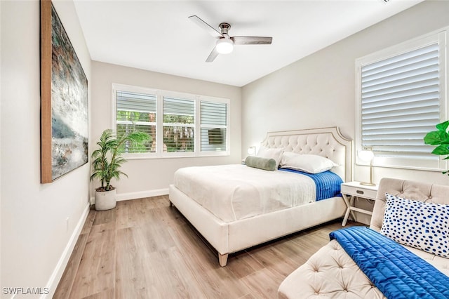 bedroom featuring ceiling fan, baseboards, and wood finished floors