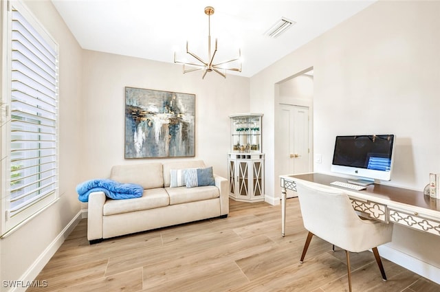 home office with light wood-type flooring, an inviting chandelier, baseboards, and visible vents