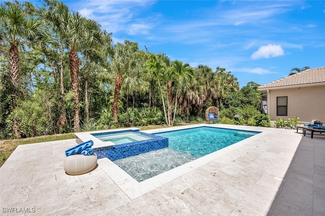 view of swimming pool featuring a pool with connected hot tub and a patio