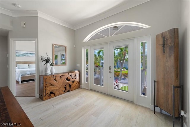 doorway featuring crown molding, light hardwood / wood-style flooring, and french doors