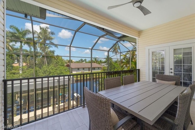 sunroom / solarium featuring a water view and ceiling fan