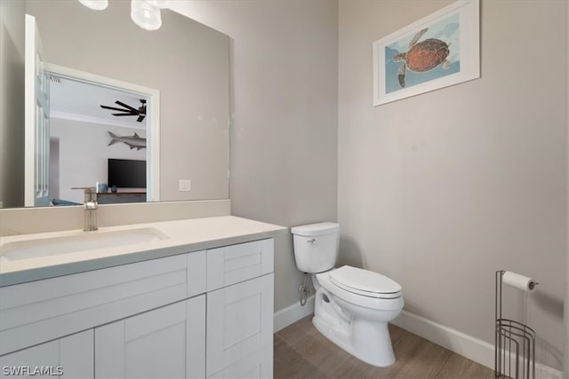 bathroom with vanity, wood-type flooring, ceiling fan, and toilet