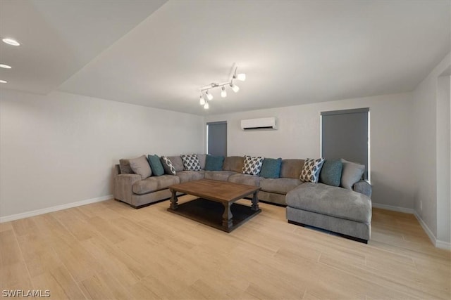 living room featuring a wall unit AC and light hardwood / wood-style flooring