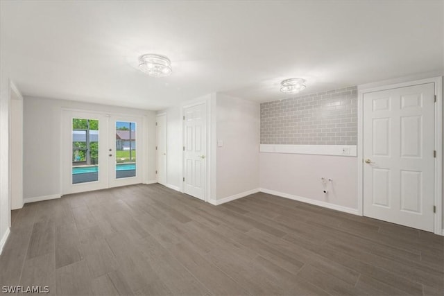 empty room featuring dark wood-type flooring and french doors