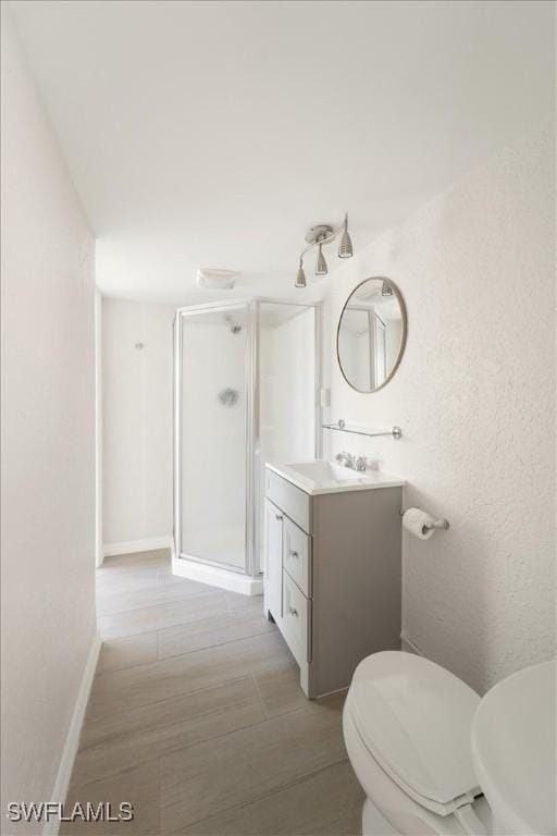 bathroom featuring an enclosed shower, vanity, and toilet