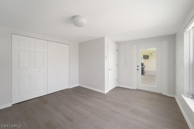 unfurnished bedroom featuring light hardwood / wood-style floors and a closet