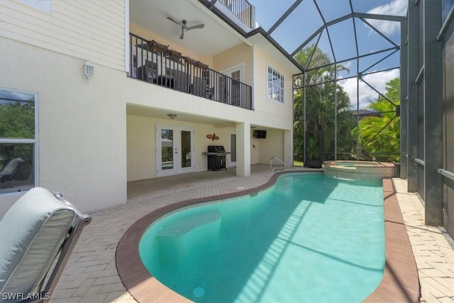 view of pool with a patio, a lanai, french doors, and an in ground hot tub