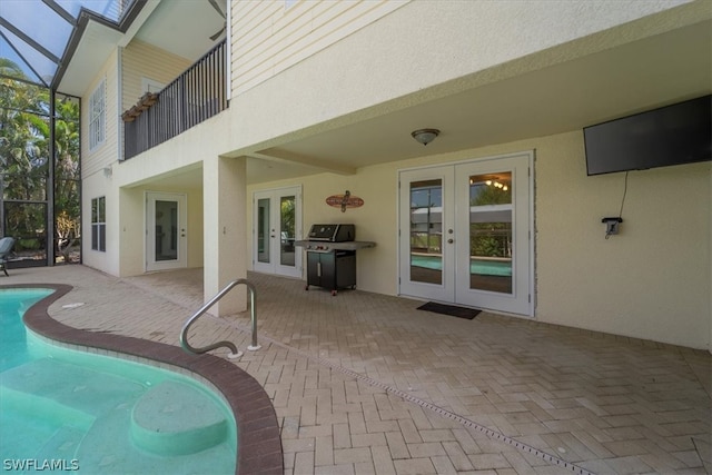 view of swimming pool featuring a lanai, grilling area, french doors, and a patio area