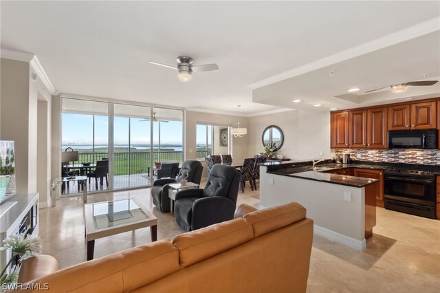 tiled living room with floor to ceiling windows, sink, a water view, ceiling fan, and ornamental molding