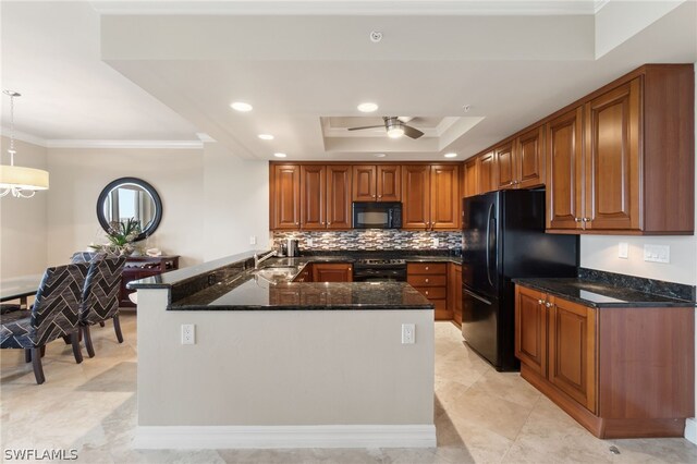 kitchen featuring light tile patterned flooring, ceiling fan, black appliances, a raised ceiling, and ornamental molding