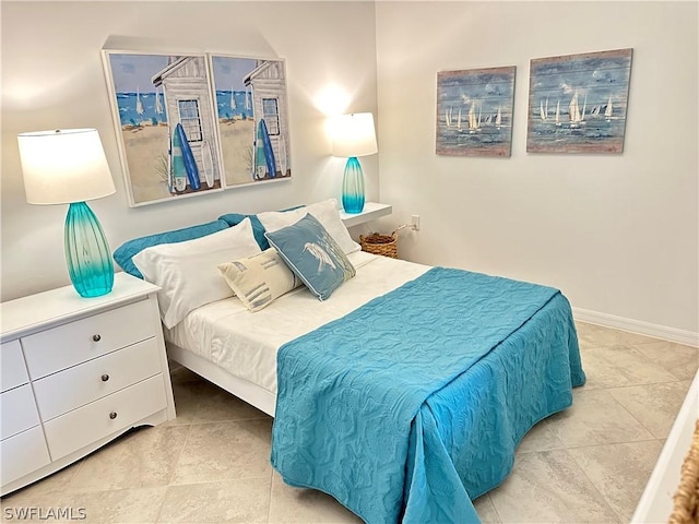 bedroom with light tile patterned flooring and baseboards