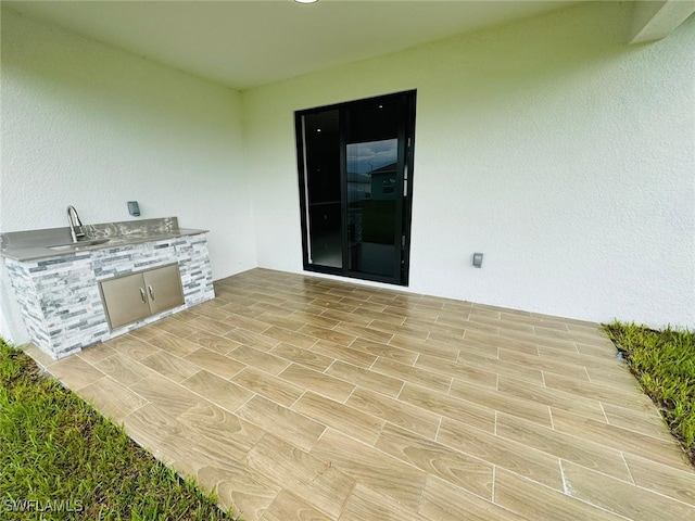 view of patio with area for grilling and sink