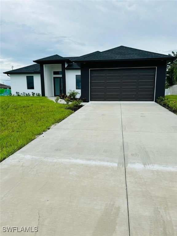 view of front of home with a front lawn and a garage