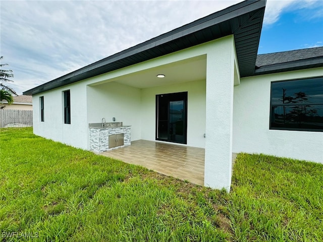 exterior space with sink, an outdoor kitchen, and a yard