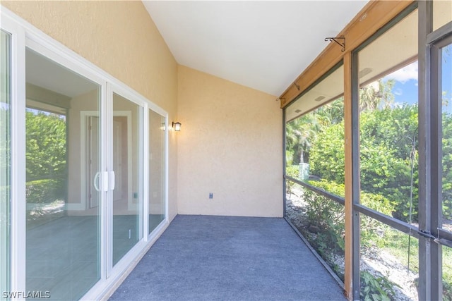 unfurnished sunroom featuring vaulted ceiling and a healthy amount of sunlight