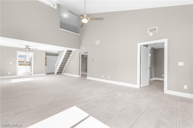 unfurnished living room featuring ceiling fan and high vaulted ceiling